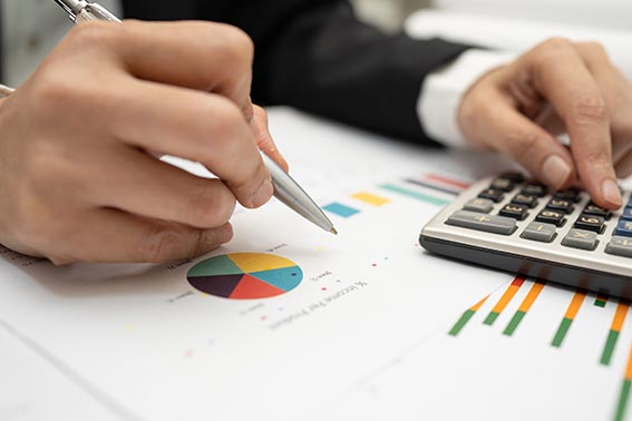 Asian accountant working and analyzing financial reports project accounting with chart graph and calculator in modern office,finance and business concept.